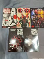 Front covers of all five Deadpool trade paperbacks laid flat