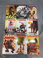 Front covers of all nine Deadpool hardcover volumes laid out 3×3