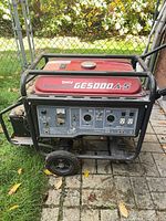 Front view showing control panel, red tank, Kawasaki GE5000A-S labeling, frame and wheels