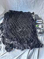 Reese 2" drop hitch with ball alongside black mesh bed cover net