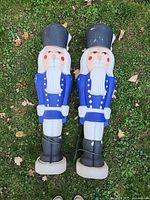 Full view of both blow-mold toy soldiers on grass