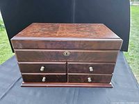 Closed view of Bombay wooden jewelry box showing burl top and brass keyhole