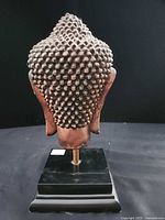 Rear view highlighting textured hair and stand