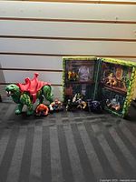 Group shot of Battle Cat, loose minis and display case