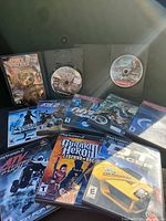 Overall lot showing all 10 PS2 game cases and open AirForce Delta Strike disc