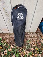 Black Yukon Charlie's carry bag standing against wall