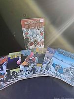 All eight The Walking Dead volumes fanned out, volume 1 standing