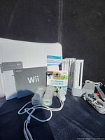 All items displayed: console, balance board, controllers, cords, manuals, games