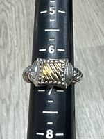 Ring on mandrel showing size and gold-accented face