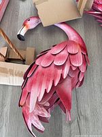 Metal flamingo body showing layered feather construction and pink gradient finish