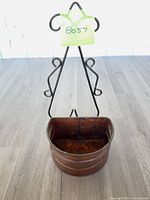 Front view of copper wall mount planter showing scroll hanger and overall form