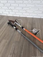 Full view of both telescoping poles on floor against brick wall