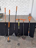 All six Fiskars garden tools lined up against a table for full view