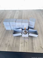 Six GaiaVilla boxed candles, two boxes opened and one glass candle displayed