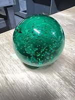 Full view of green glass paperweight showing bubble pattern