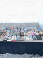 Wide shot showing all DVD and Blu-ray cases laid out on table (~48 cases)