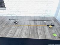 Two rods laid out on tabletop showing full length and attached reels