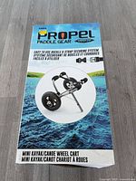Front of retail box displaying Propel Paddle Gear mini kayak/canoe wheel cart image and specs