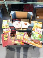 Overview of 11 cookbooks arranged on table, showing mix of titles