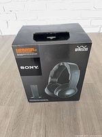 Front of retail box showing headphones and transmitter