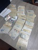 Tabletop view showing numerous glassine envelopes and some loose bags of stamps