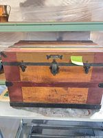 Front and top view of wooden travel trunk on shelf