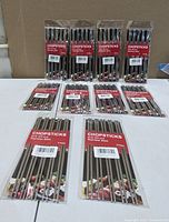 Nine sealed packs of stainless steel chopsticks displayed on table