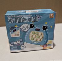 Front of boxed V3 Quick Push game showing product image, features and age rating