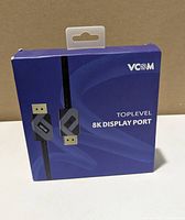 Front of sealed retail box showing VCOM branding and 8K DisplayPort label
