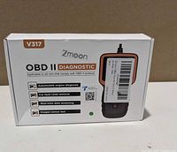 Front of box showing Zmoon V317 OBD II Diagnostic scanner branding and feature list