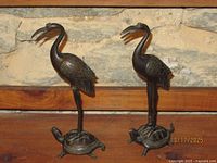 Front view of both bronze crane figurines on turtle bases