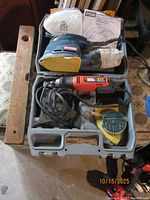 Open case showing Ryobi sander, Black & Decker rotary tool, sanding pads, manual and dust bag