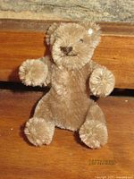 Front view of 3.5-inch brown Steiff miniature bear with ear button visible