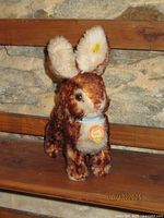 Front view of Steiff Ossi rabbit showing chest tag, blue ribbon, overall condition