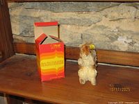 Steiff squirrel plush standing beside original striped box