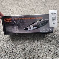 Front of sealed OUDEMU car vacuum cleaner box