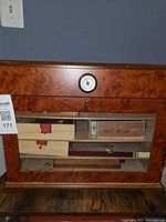 Front view of burl wood humidor showing glass door, hygrometer and interior boxes