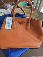 Front view showing Prada logo plaque and pebbled leather