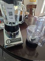 Blender jar on motor base beside processor bowl