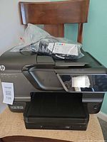 Front view of HP Officejet Pro 8600 printer with ink pack resting on top