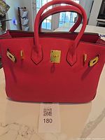 Front view of pink tote showing gold-tone hardware and handles