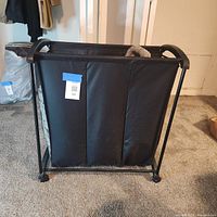 Front view of black metal frame hamper with three mesh sections