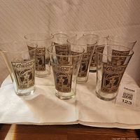 Front view of all eight Coca-Cola glasses displaying artwork