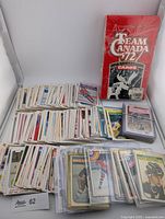 Loose spread of multiple stacks of hockey cards and Team Canada box visible