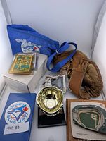 Group shot showing glove, gold glove trophy, card stacks, box, Blue Jays bag, Fenway Park model