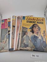 Front view of stacked comics showing Linda Lark Student Nurse cover with additional titles behind, in sleeves