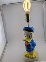 Full view of Donald Duck vinyl table lamp showing figure base, metal neck and socket