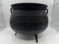 Front view showing ribbed cast iron cauldron with three legs