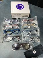 Box with Joy logo, nine sealed glasses, pouch