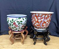 Two ceramic planters on respective wooden stands